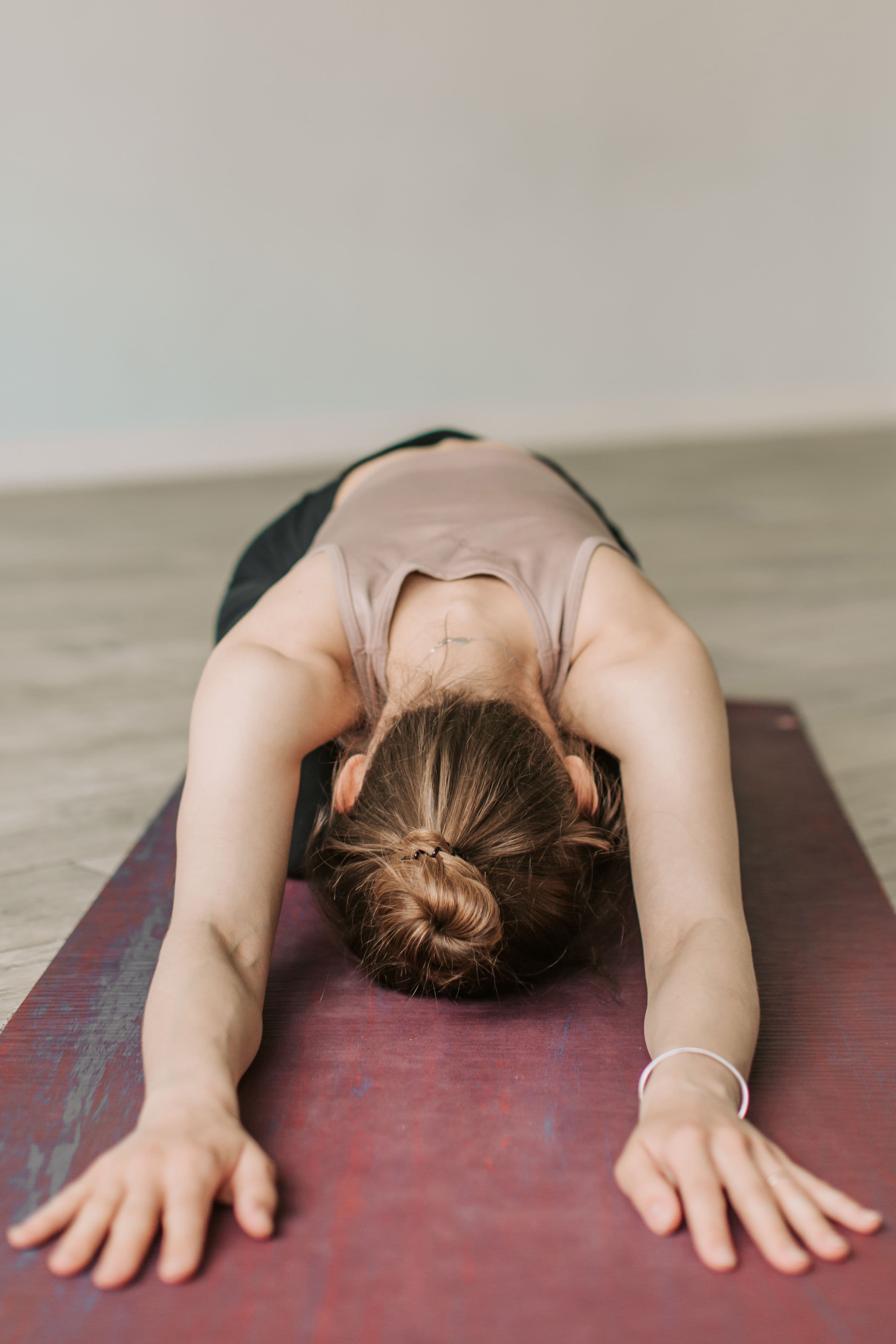 A woman resting in child's pose on a mat during a restorative indoor session